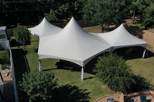 Aerial view of a triple-peak marquee tent in a backyard
